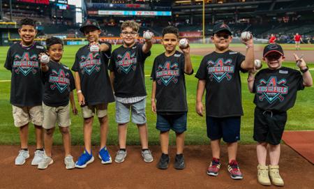 7 winners of the Kids take the field giveaway from the Husband and Wife Law Team together on field before the game