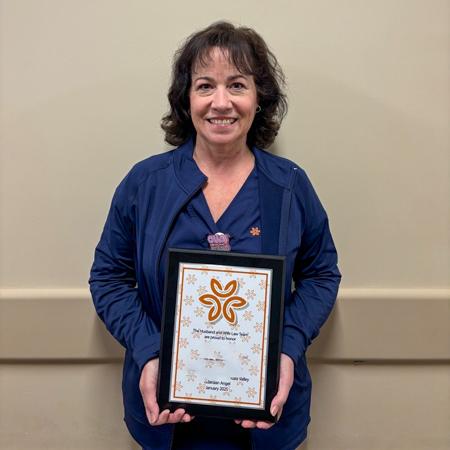 Nurse Faith holding her Guardian Angel award