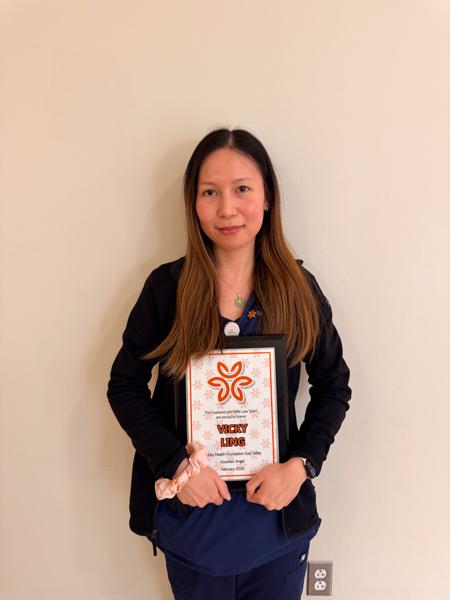 Vicky holding a framed certificate which says Guardian Angel Award. A testament to her dedication