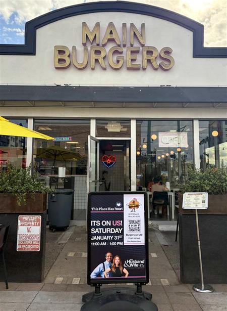 Restaurant entrance with "Main Burgers" sign, a notice board advertising a free burger event