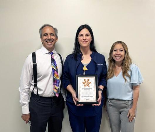 Nurse Sara displays her award with Mark and Alexis Breyer